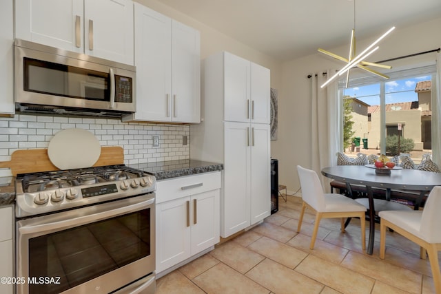 29 W Camino Rancho Viejo, Sahuarita, AZ 85629 - kitchen featuring stainless steel appliances, decorative backsplash, white cabinetry, light tile patterned flooring, and dark stone countertops
