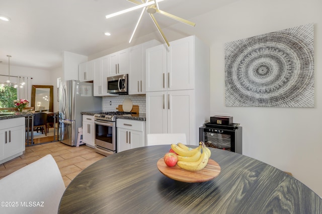 29 W Camino Rancho Viejo, Sahuarita, AZ 85629 - kitchen with stainless steel appliances, tasteful backsplash, white cabinetry, decorative light fixtures, and a chandelier