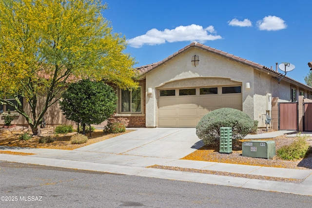 11413 E Squash Blossom Loop, Tucson, AZ 85747 - view of front of home with a garage, concrete driveway, stucco siding, and fence