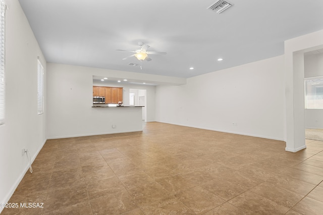 11413 E Squash Blossom Loop, Tucson, AZ 85747 - unfurnished living room featuring ceiling fan, plenty of natural light, recessed lighting, and baseboards