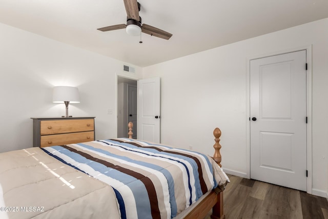 bedroom featuring baseboards, visible vents, a ceiling fan, and wood finished floors