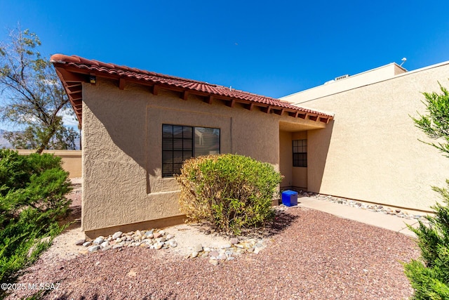 view of property exterior featuring a tile roof and stucco siding