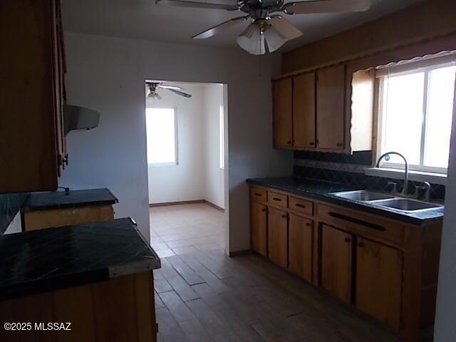 2491 N Joe Hines Rd, Willcox, AZ 85643 - kitchen with a sink, ceiling fan, wood finished floors, dark countertops, and baseboards