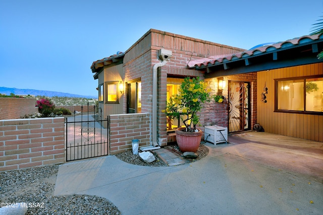 exterior space with a mountain view, fence, and a gate