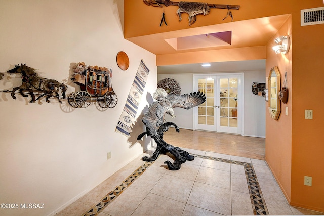 tiled foyer entrance with baseboards, french doors, and visible vents
