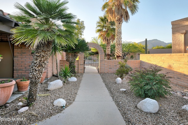 view of yard featuring a mountain view, a gate, and fence