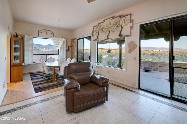 dining room featuring light tile patterned floors, a notable chandelier, baseboards, and a mountain view