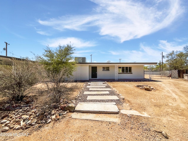 view of front of home featuring stucco siding and fence
