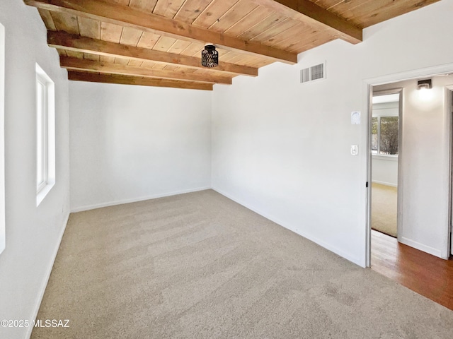 carpeted spare room with baseboards, beam ceiling, visible vents, and wood ceiling