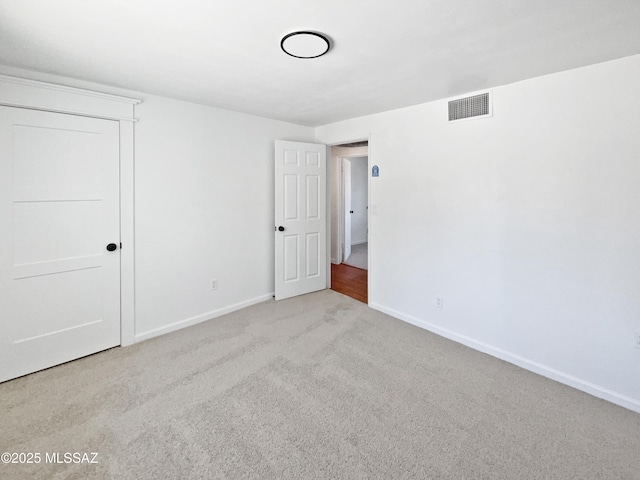 unfurnished bedroom featuring baseboards, visible vents, and carpet floors