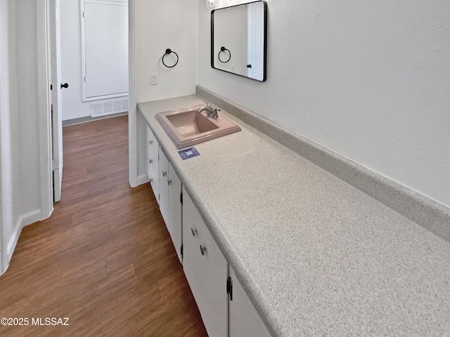 bathroom featuring visible vents, wood finished floors, and a sink