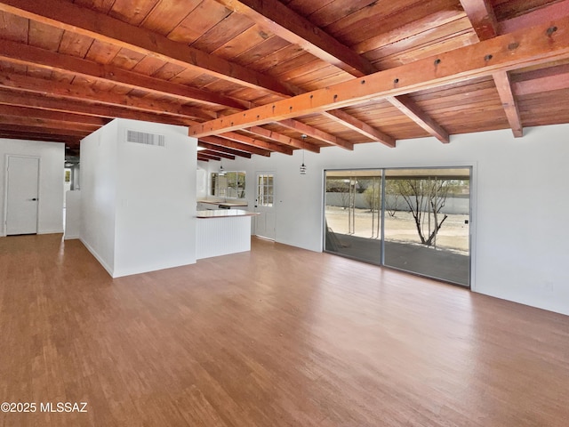 unfurnished living room featuring wooden ceiling, beamed ceiling, visible vents, and wood finished floors