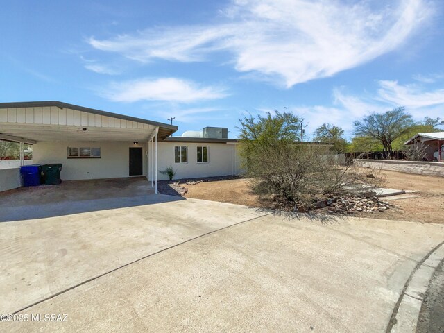 123 N Regency Pl, Tucson, AZ 85711 - rear view of property featuring concrete driveway, stucco siding, and an attached carport