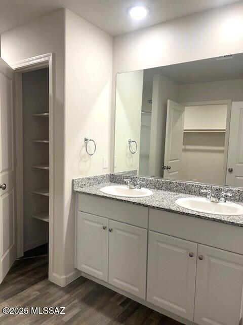 365 S Redwood Loop, Benson, AZ 85602 - bathroom featuring wood finished floors, double vanity, and baseboards
