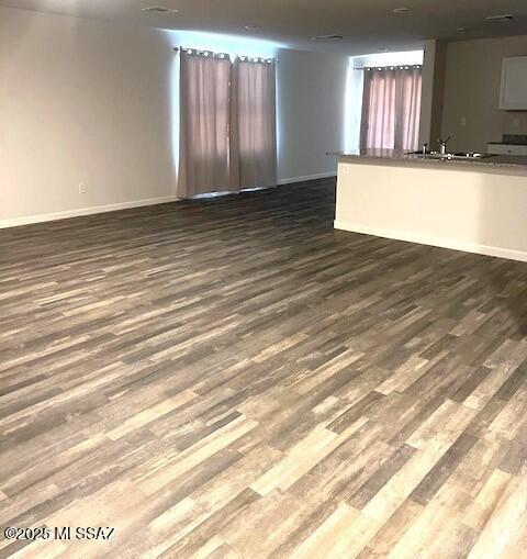 365 S Redwood Loop, Benson, AZ 85602 - unfurnished living room featuring dark wood-type flooring and baseboards