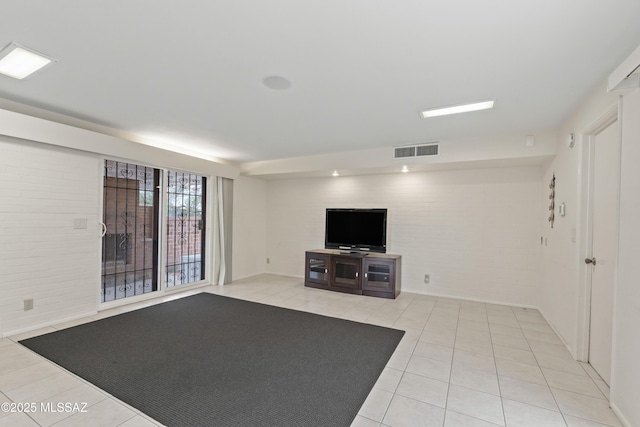 1047 E Hedrick Dr, Tucson, AZ 85719 - unfurnished living room featuring light tile patterned flooring and brick wall