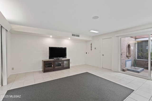 1047 E Hedrick Dr, Tucson, AZ 85719 - unfurnished living room with light tile patterned floors, baseboards, and brick wall