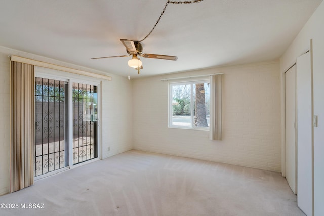 1047 E Hedrick Dr, Tucson, AZ 85719 - unfurnished bedroom with multiple windows, carpet flooring, brick wall, a ceiling fan, and access to outside