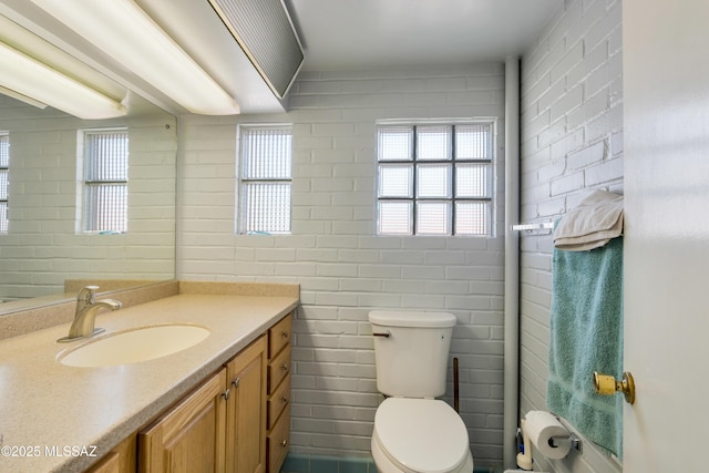 1047 E Hedrick Dr, Tucson, AZ 85719 - bathroom with vanity, toilet, and brick wall