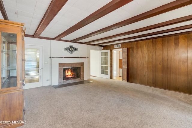 1047 E Hedrick Dr, Tucson, AZ 85719 - unfurnished living room featuring carpet flooring, beamed ceiling, a fireplace with flush hearth, and wood walls