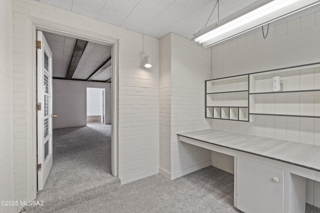 1047 E Hedrick Dr, Tucson, AZ 85719 - unfurnished office featuring light colored carpet, built in study area, and brick wall