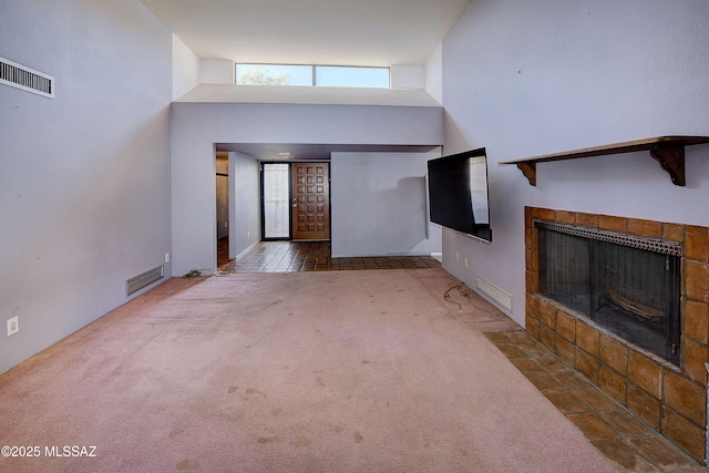 810 E Placita Leslie, Tucson, AZ 85718 - unfurnished living room with visible vents, a fireplace, a high ceiling, and carpet floors