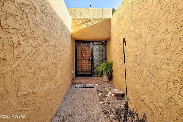 810 E Placita Leslie, Tucson, AZ 85718 - view of exterior entry featuring stucco siding and a gate