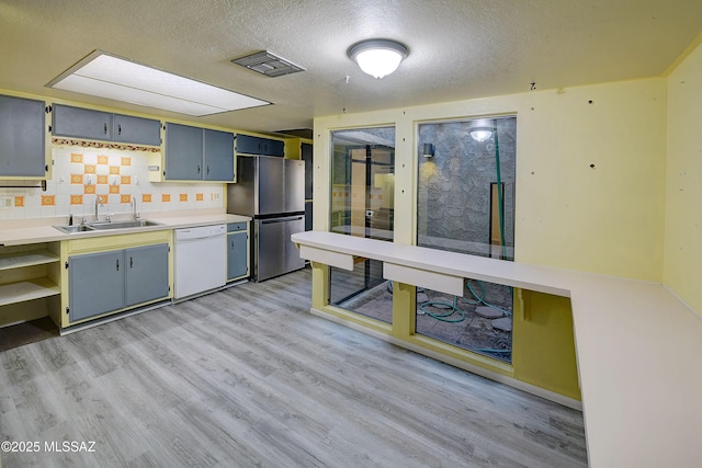 810 E Placita Leslie, Tucson, AZ 85718 - kitchen featuring freestanding refrigerator, dishwasher, light wood-style flooring, and a sink