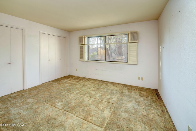 810 E Placita Leslie, Tucson, AZ 85718 - unfurnished bedroom featuring multiple closets and carpet floors