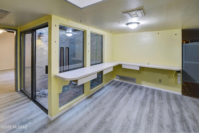 810 E Placita Leslie, Tucson, AZ 85718 - interior space featuring a textured ceiling, visible vents, wood finished floors, and baseboards