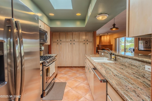 149 E Los Arcos, Green Valley, AZ 85614 - kitchen featuring light tile patterned floors, a sink, a skylight, appliances with stainless steel finishes, and light stone counters