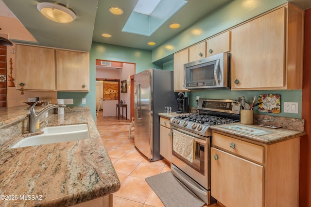 149 E Los Arcos, Green Valley, AZ 85614 - kitchen featuring a sink, a skylight, stainless steel appliances, light tile patterned flooring, and light brown cabinetry