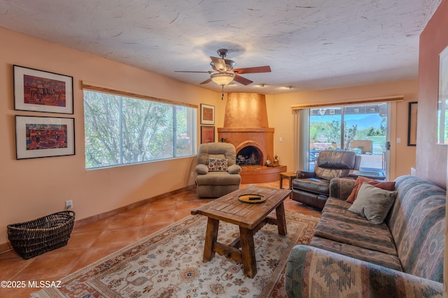 149 E Los Arcos, Green Valley, AZ 85614 - tiled living room featuring a large fireplace, baseboards, a ceiling fan, and a healthy amount of sunlight