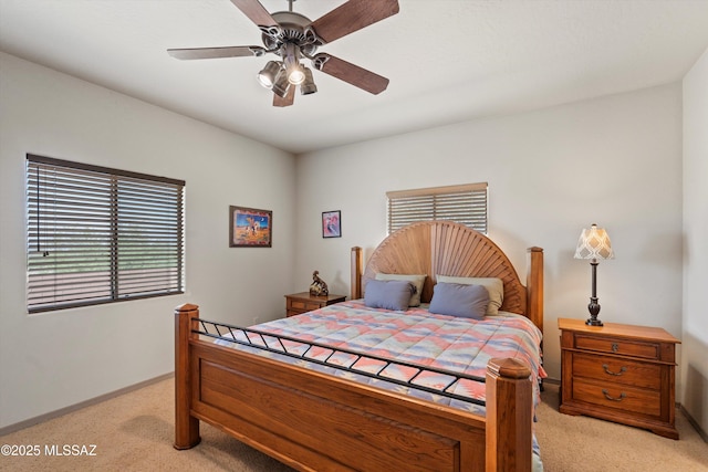 bedroom featuring light colored carpet, baseboards, and a ceiling fan