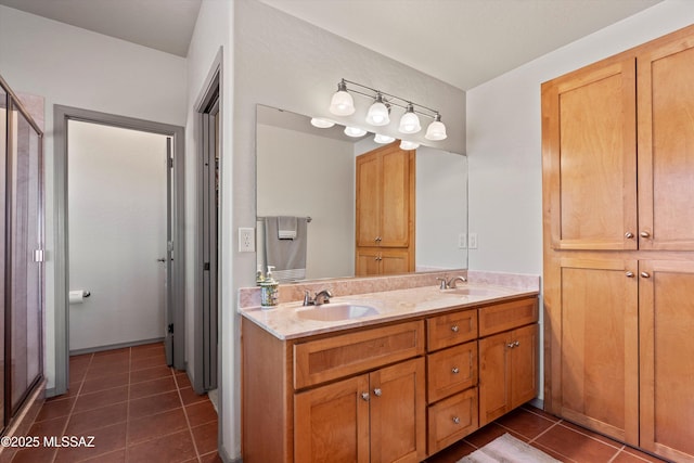 full bath featuring tile patterned floors, double vanity, and a shower with door