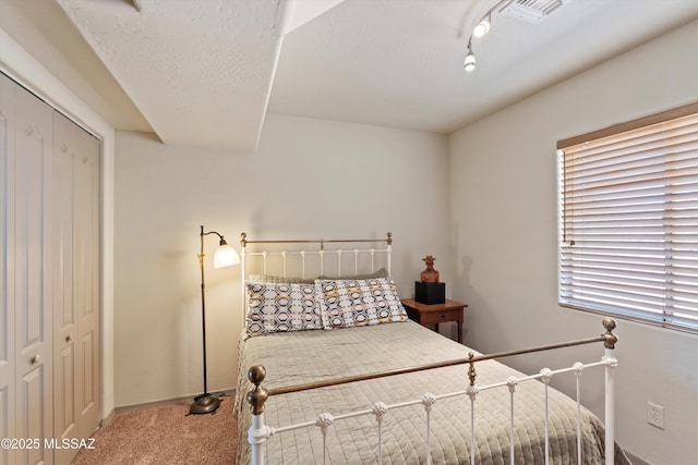 carpeted bedroom with baseboards, a closet, and a textured ceiling