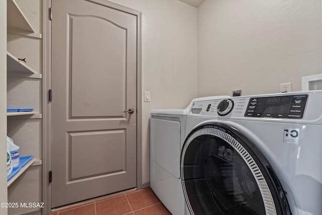 laundry area with washing machine and clothes dryer and tile patterned floors