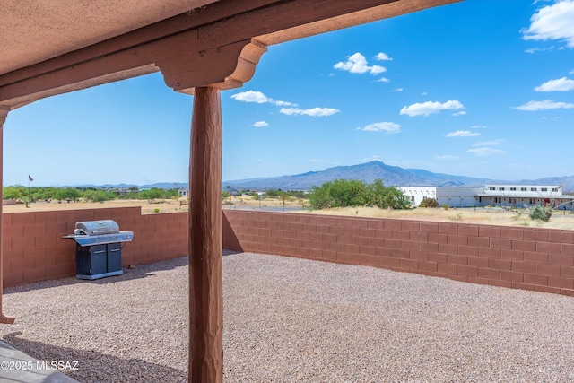 view of patio / terrace with area for grilling, a mountain view, and a fenced backyard