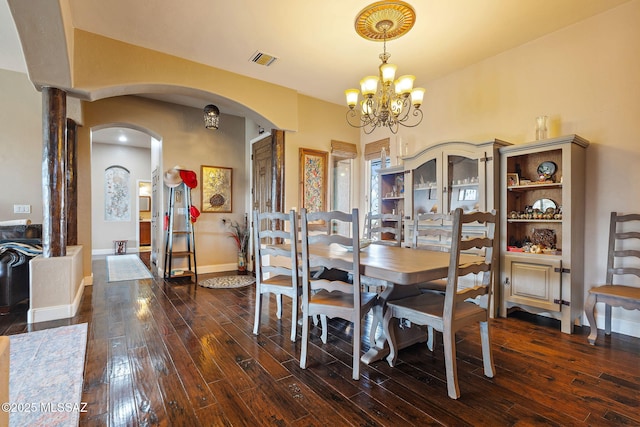33 Camino Olympia, Rio Rico, AZ 85648 - dining area featuring arched walkways, dark wood finished floors, a chandelier, and baseboards