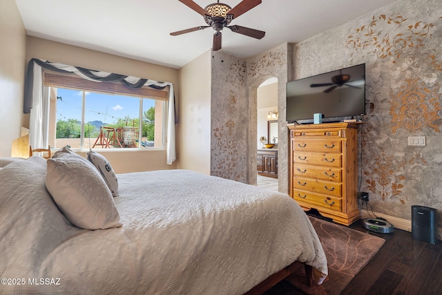 33 Camino Olympia, Rio Rico, AZ 85648 - bedroom with wood finished floors, arched walkways, baseboards, ceiling fan, and connected bathroom