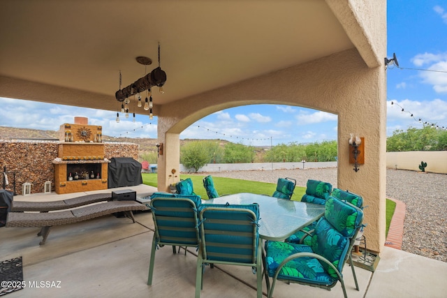 33 Camino Olympia, Rio Rico, AZ 85648 - view of patio with an outdoor stone fireplace, a fenced backyard, and outdoor dining space