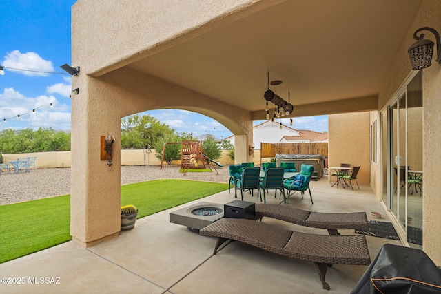 33 Camino Olympia, Rio Rico, AZ 85648 - view of patio / terrace with a playground, a covered hot tub, outdoor dining area, and an outdoor fire pit