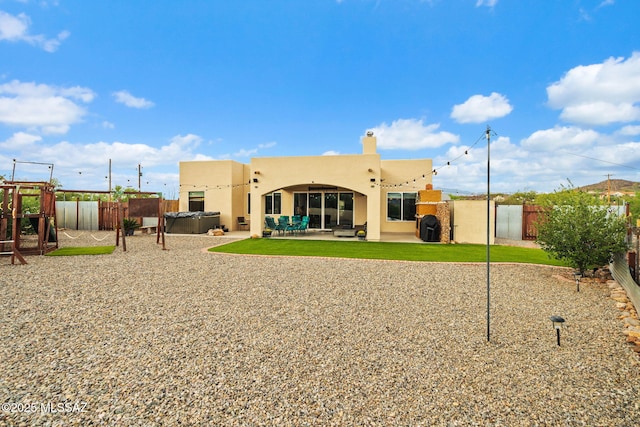 33 Camino Olympia, Rio Rico, AZ 85648 - rear view of property with a hot tub, stucco siding, a fenced backyard, and a patio
