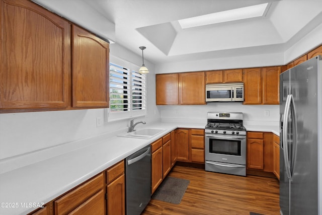 11846 N Copper Butte Dr, Oro Valley, AZ 85737 - kitchen with stainless steel appliances, a sink, a tray ceiling, and brown cabinets
