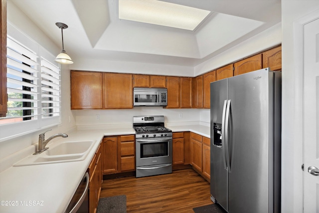 11846 N Copper Butte Dr, Oro Valley, AZ 85737 - kitchen featuring stainless steel appliances, a sink, brown cabinetry, dark wood-style floors, and a tray ceiling