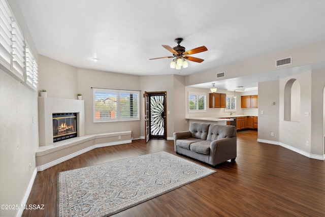 11846 N Copper Butte Dr, Oro Valley, AZ 85737 - living area featuring dark wood-type flooring, baseboards, ceiling fan, and a tile fireplace