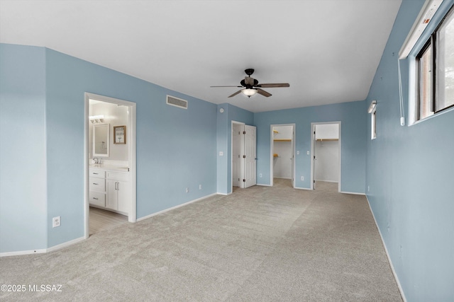11846 N Copper Butte Dr, Oro Valley, AZ 85737 - unfurnished bedroom with light carpet, baseboards, ensuite bathroom, and a spacious closet