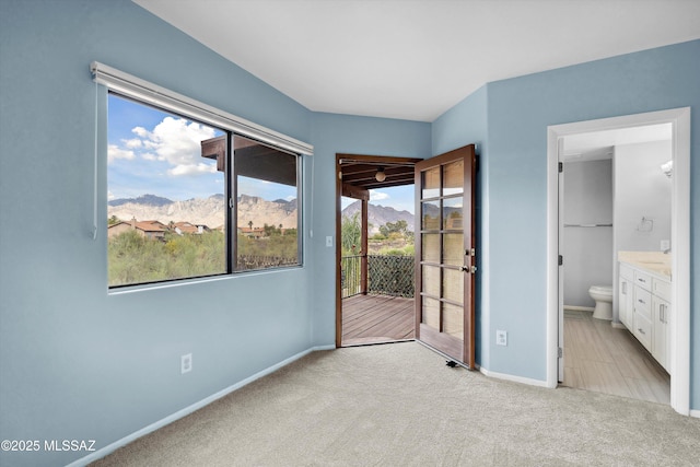 11846 N Copper Butte Dr, Oro Valley, AZ 85737 - unfurnished bedroom featuring access to exterior, a mountain view, light colored carpet, baseboards, and ensuite bath
