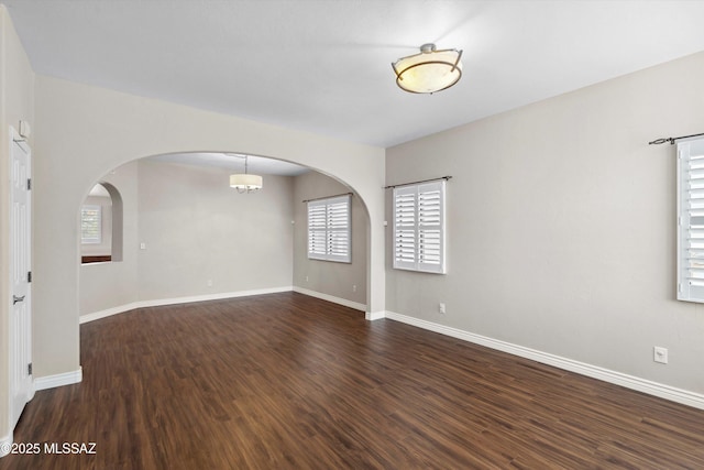 11846 N Copper Butte Dr, Oro Valley, AZ 85737 - unfurnished room featuring wood finished floors, plenty of natural light, arched walkways, and baseboards