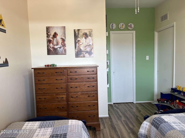 bedroom with baseboards, visible vents, and dark wood-style floors